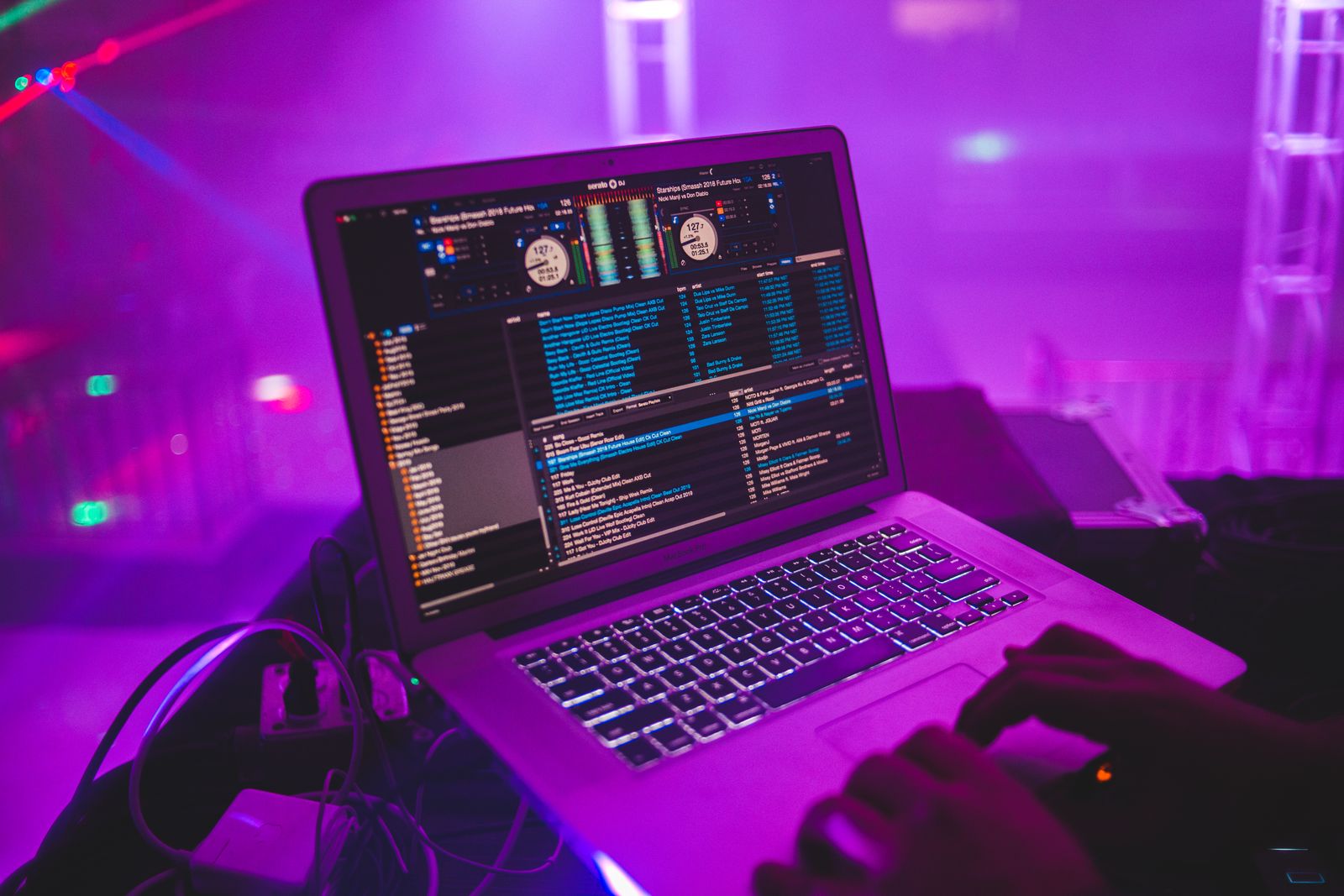 DJ operating a laptop with music software in a club